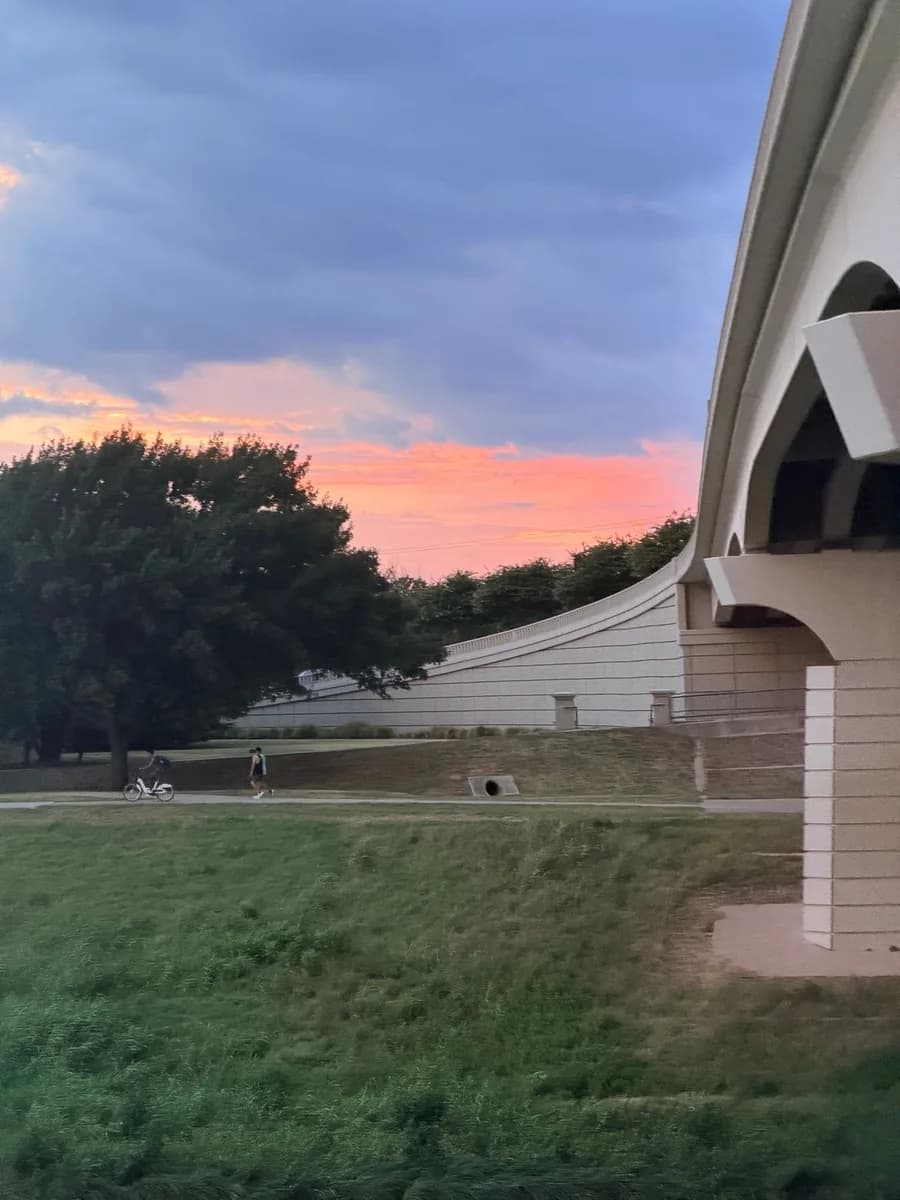 A runner on the Trinity Trails under the Seventh Street bridge at sunset